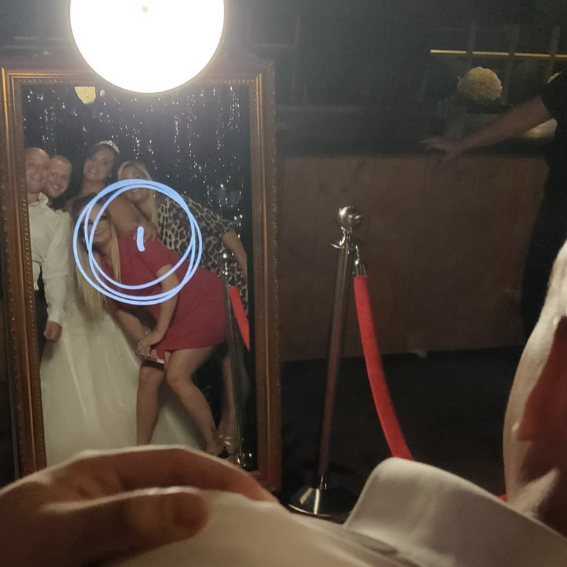 Gasten poseren samen in de Mirrorbooth op een bruiloft